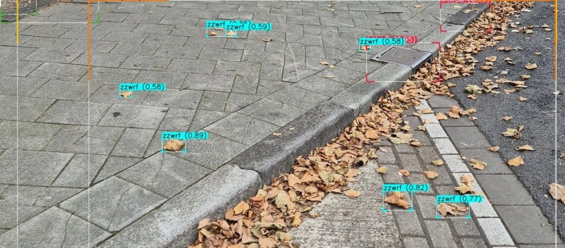 AI-inspectie openbare ruimte in herfst: model herkent zwerfafval en kolkinlaten, false positive veroorzaakt door bladeren en schaduw.